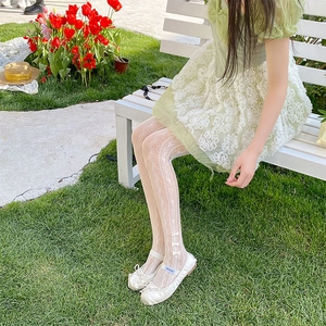 Detail of white lace tights with hollow heart patterns and 3D bows at the ankles