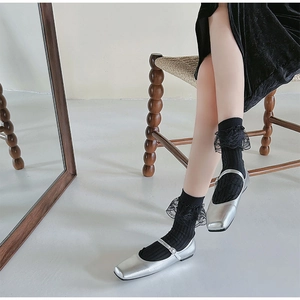 Silver square-toe Mary Jane flats paired with black lace-trimmed ribbed crew socks