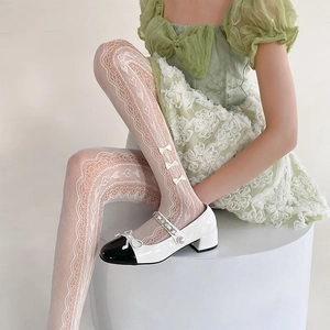 Detail of white lace tights featuring 3D cream bows and elegant hollow-out mesh texture