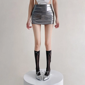Detail of Lolita style mesh socks with black bows paired with a silver metallic skirt