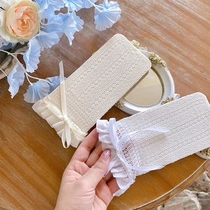 Detail of white lace mesh socks with bow ribbon and elegant ruffled edges in vintage style