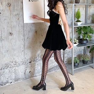 Detail of floral lace tights styled with velvet mini dress and platform Mary Jane shoes