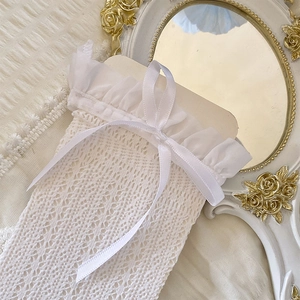 Detail of white lace mesh socks featuring delicate bow accents and ruffled trim design