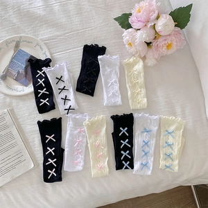 Détails de chaussettes hautes Lolita avec dentelle et nœuds rubans en vue de dessus
