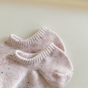Detailed macro view of light pink nep yarn knit socks with ribbed texture and speckled design