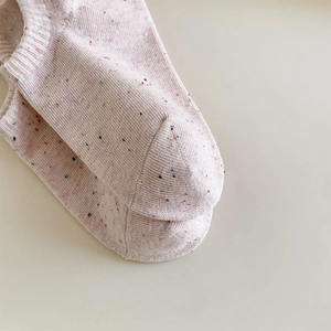 Close-up of pink knit socks featuring colorful flecks and reinforced toe seam detail
