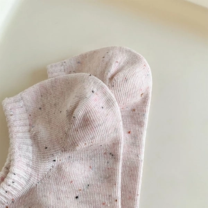 Detailed close-up of pink flecked knit ankle socks showing ribbed cuffs and soft texture