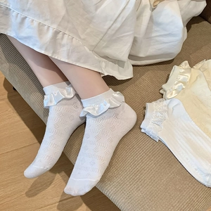 Détail de chaussettes Lolita blanches avec jacquard en maille et bordure en satin dentelle
