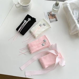 Flat lay of knit leg warmers with star appliques and pink ribbon bows in three colors