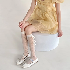 Lacy mesh knee high socks with ribbon bows styled with white ballet flat shoes
