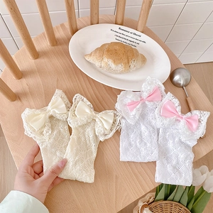 Detailed macro view of infant lace bow socks with delicate openwork mesh in two colors