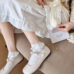 Détail de chaussettes Lolita blanc crème avec volants en dentelle et motifs jacquard ajourés