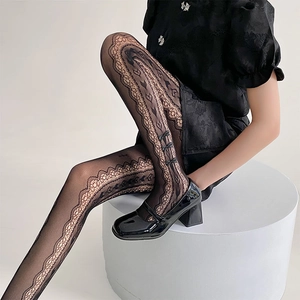 Detail of black lace tights featuring scalloped edges and 3D bow accents with Mary Janes