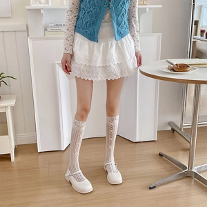 Détail de chaussures Mary Jane blanches avec chaussettes en dentelle et nœuds rubans