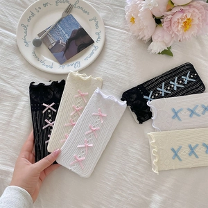 Détail de chaussettes en dentelle ajourée avec nœuds et bordures à volants
