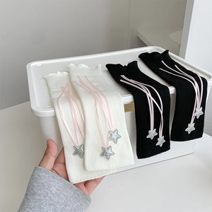 Detail of sweet Lolita leg warmers with pink ribbons and glittery star pendants