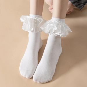 Detailed close-up of white JK princess socks with elegant satin ribbon ruffles and knit texture