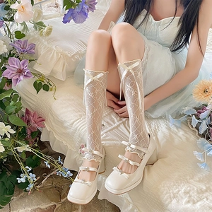 Detail of white lace mesh leg warmers with ribbon bows and platform Mary Jane shoes