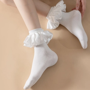 Close-up of white Lolita socks featuring decorative satin ruffles and elegant lace texture