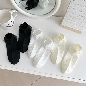 Détail de trois paires de chaussettes Lolita avec dentelle en noir, blanc et crème
