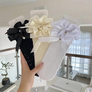 Gros plan de chaussettes résille à cœur avec volants en dentelle et nœuds en satin