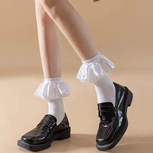 Detail of white ruffle trim socks paired with shiny black platform loafers for JK style
