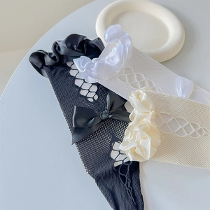 Detail of Lolita knee-high socks featuring lace mesh patterns and silk bow accents