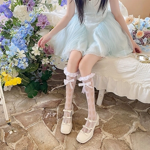Détail de chaussettes blanches en dentelle avec motifs cœur, nœuds et perles