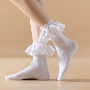 Detailed view of white mid-calf socks with elegant satin ruffle trim and lolita style finish