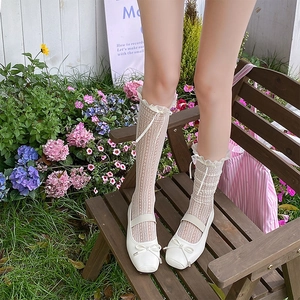 Detailed view of white lace mesh calf socks with bow ribbons and Mary Jane ballet flats