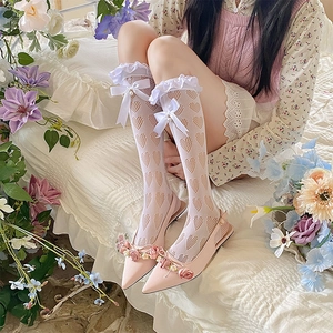 Détail de chaussettes résille à cœurs blancs avec volants en dentelle et nœud mignon