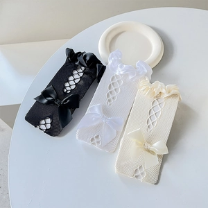 Close-up of lolita fishnet socks with ruffled lace trim and large satin bows in three colors