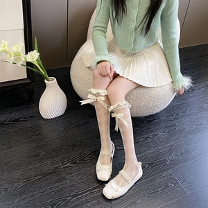 Détail de chaussettes blanches résille à cœurs avec volants et un nœud perlé doux