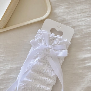 Detail of white Lolita lace arm sleeves featuring delicate bows and ruffled edge trim