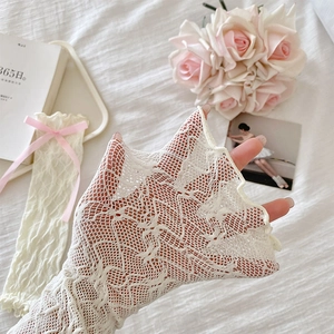 Close-up of cream lace sleeve protector with pink ribbon bow and floral texture