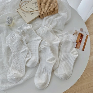 Vue détaillée de chaussettes blanches en coton avec divers motifs et bordures en dentelle