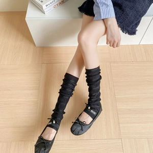 Black ballet style leg warmers with pleated texture and delicate bow pearl accents