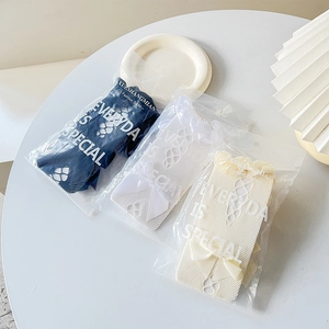 Detailed view of Lolita lace mesh socks with silk bows in blue, white, and cream tones