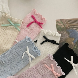 Gros plan de chaussettes en résille avec bords à volants et nœuds en six couleurs