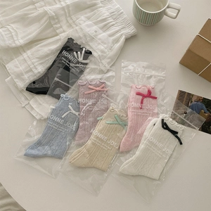 Détails de chaussettes à volants avec nœuds et motifs en maille ajourée respirante