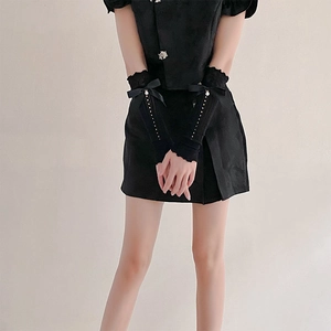 Detail of black lace arm sleeves with satin bows and pearl beads in gothic style