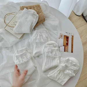 Détail de cinq paires de chaussettes Lolita blanches avec dentelle et nœuds en soie