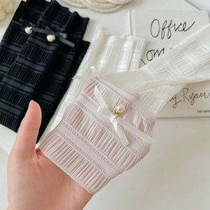 Detail of ballet style leg warmers with delicate bows and pearl accents on ribbed fabric
