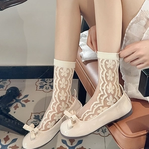 Close-up of white floral lace socks paired with cream bow loafers for a sweet style