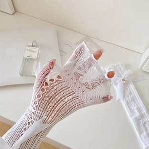 Detail of white lace mesh gloves featuring delicate satin bows and pearl embellishments