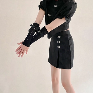 Detail of black lace fingerless sleeves with delicate pearl bow and silver frog buttons