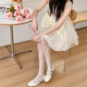 Détail de collants en résille blancs avec motif jacquard ballerines et nœuds