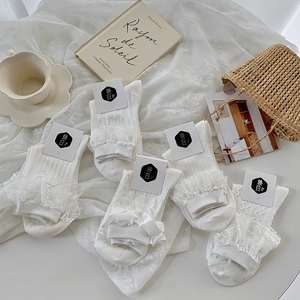 Détail de cinq paires de chaussettes Lolita blanches avec dentelle et nœuds en satin