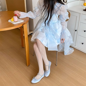Gros plan sur des bas Lolita blancs à motifs de nœuds avec des ballerines bleues