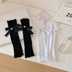 Detail of lace arm sleeves with bows and pearls in white and black balletcore style